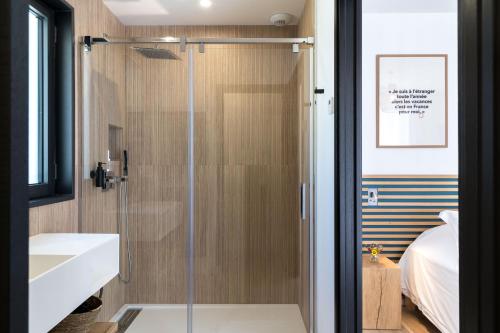 une douche avec une porte vitrée dans une salle de bain dans l'établissement Les Roches Blanches-Montferrat, à Montferrat