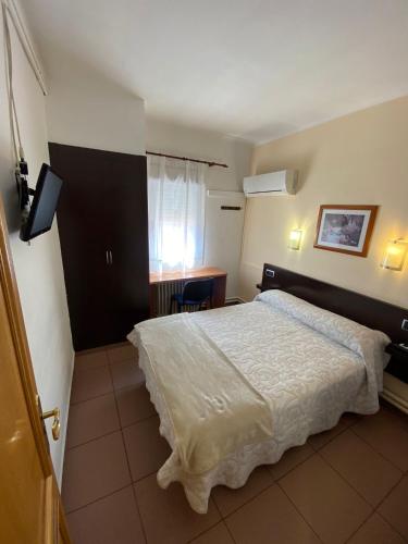 a bedroom with a white bed and a window at Hotel Alegret in Tremp