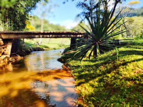 a bridge over a river with a creekensionalensionalensionalensionalensionalensionalensionalensional at Chácara Brisa do Rio 2 in Núcleo Colonial