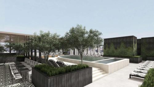 a courtyard with a pool and benches and trees at Hotel Bourre Bonne Louisville, Curio Collection by Hilton in Louisville