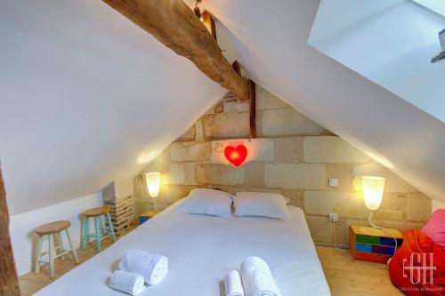 une chambre avec un lit blanc dans un grenier dans l'établissement Glorisa - Quartier historique, à Tours