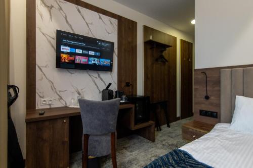 a hotel room with a desk and a tv on a wall at Sleep&Fly Okęcie Warsaw Airport in Warsaw