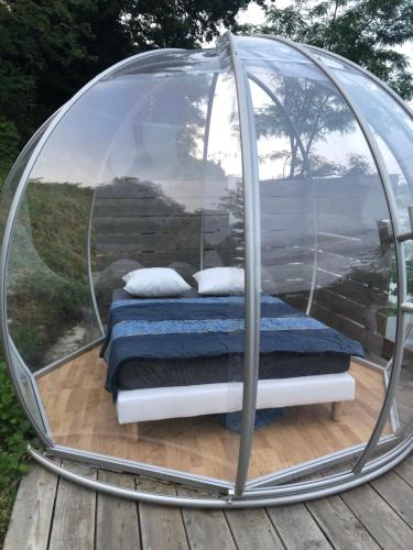 - un lit dans une tente en forme de dôme sur une terrasse dans l'établissement Chalet et Bulle La tête dans les étoiles, à Audelange