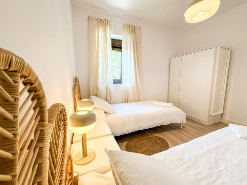 um quarto com duas camas e uma janela em A Casa de Canosiña by ALÔGA em Fisterra