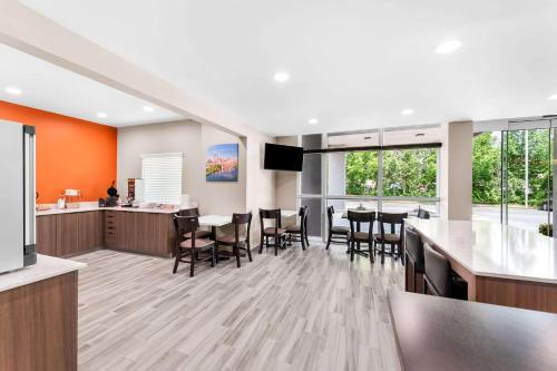 cocina abierta y comedor con mesas y sillas en Sleep Inn & Suites Pigeon Forge Downtown, en Pigeon Forge