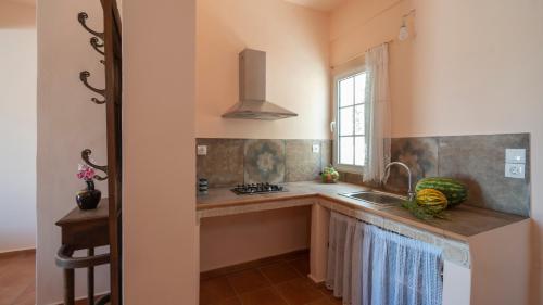 a kitchen with a sink and a window at Ροδον in Agia Marina