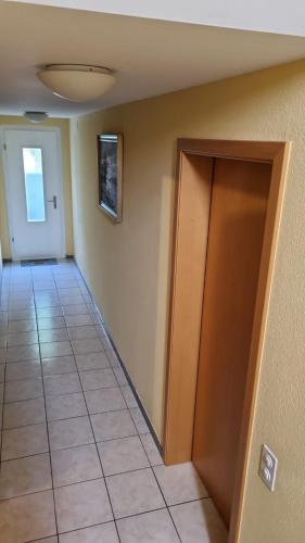 an empty hallway with a door and a tile floor at Studio Chris in Cadenazzo