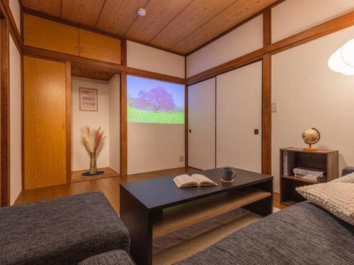a living room with a table with a book on it at Discover Tokyo's soul Your cozy Japanese escape! in Tokyo