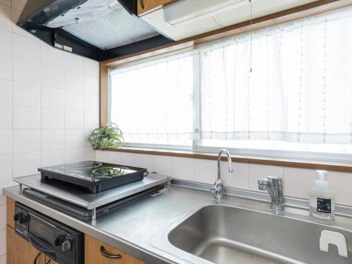 a kitchen with a sink and a window at Discover Tokyo's soul Your cozy Japanese escape! in Tokyo