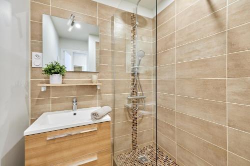 une salle de bain avec douche et lavabo dans l'établissement OIQIA • Intemporel, à Cabourg