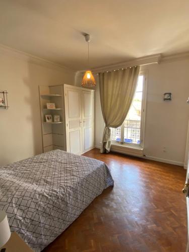 una camera da letto con un letto e una finestra di Appartement 6 Chambres Coeur de Ville a Soissons