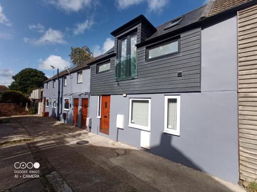 a white and gray building with orange doors on a street at BexLet in Bexhill