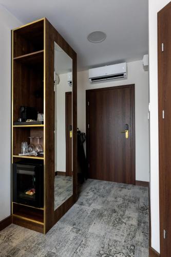 a hallway with a wooden door and a mirror at Sleep&Fly Okęcie Warsaw Airport in Warsaw