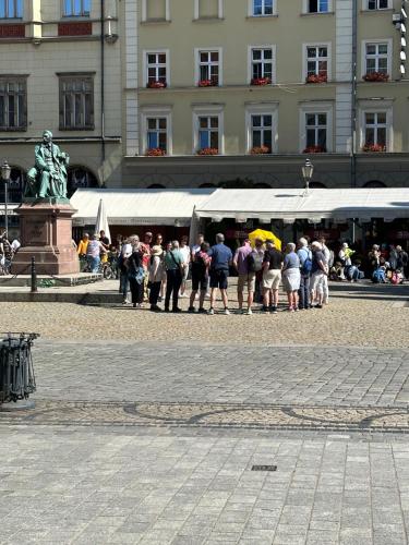eine Gruppe von Menschen steht vor einem Gebäude in der Unterkunft Rynek pod Fredrą in Breslau