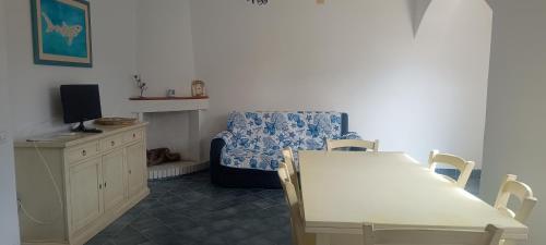 a living room with a table and a blue chair at Trilo Lu Rattali in San Teodoro