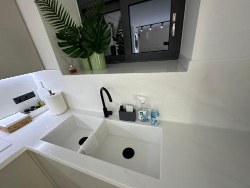 a white sink in a bathroom with a mirror at ILION Villa in Athens
