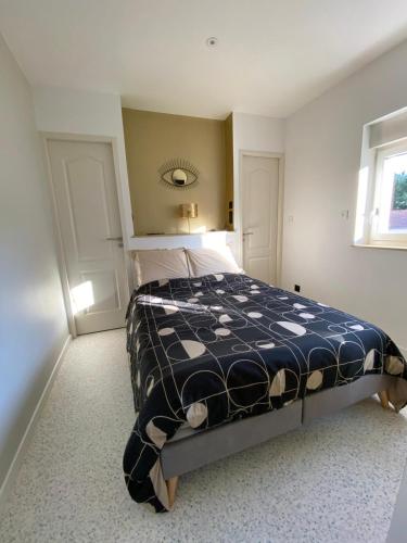 a bedroom with a bed with a black and white comforter at En face de la Basilique de Saint Nicolas-de-Port in Saint-Nicolas-de-Port