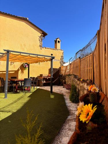 a patio with a fence and a table with flowers at Casa Rural Abuelo Regino in Segovia