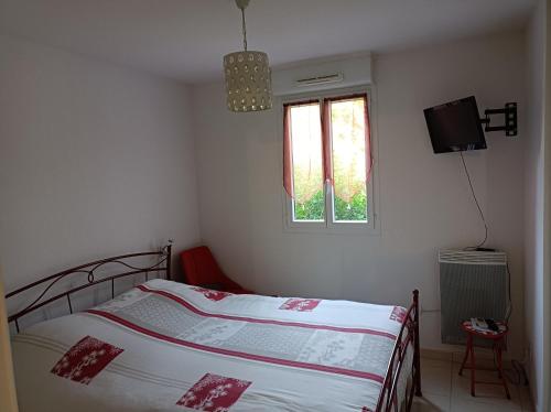 une petite chambre avec un lit et une fenêtre dans l'établissement Havre de paix, à Fréjus