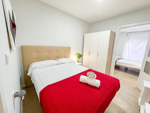 a bedroom with a bed with a red blanket at Trinidad del Mar Turistea in Castellón de la Plana