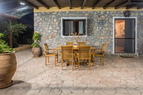 a patio with a wooden table and chairs at Villa in the Woods in Kolimbia