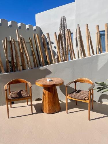 two chairs and a wooden table next to a wall at Luna Santorini Suites in Pirgos