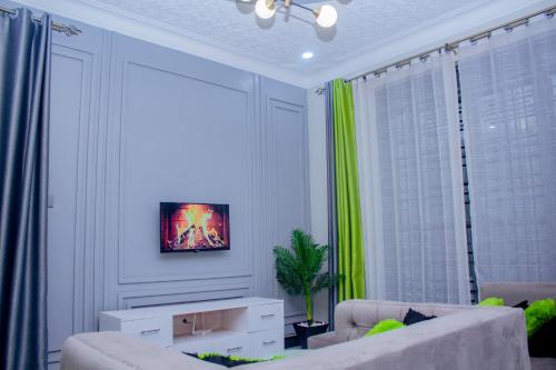 a living room with two couches and a painting on the wall at Cozy Residence I, 1 bedroom Apartment Kyanja in Kampala
