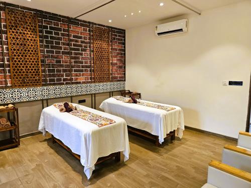 a room with two beds and a brick wall at Bhanu The Fern Forest Resort & Spa, Jambughoda in Jambughoda
