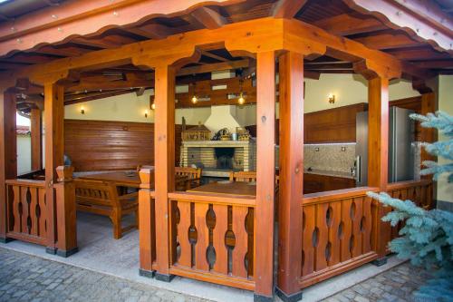 a wooden gazebo with a table and a kitchen at Парк-Хотел Клементина in Trud