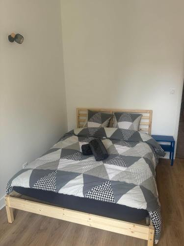 un lit avec une couette et des oreillers noirs et blancs dans l'établissement A supprimer, à Grenoble
