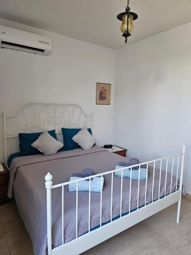 a bedroom with a white bed with blue pillows at Summer Bliss Apartment Peyia in Peyia