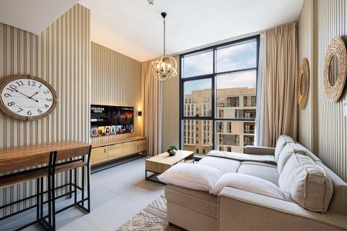 a living room with a couch and a clock on the wall at 1BR Private Poolview Apartment - Poolside Paradise in Sharjah