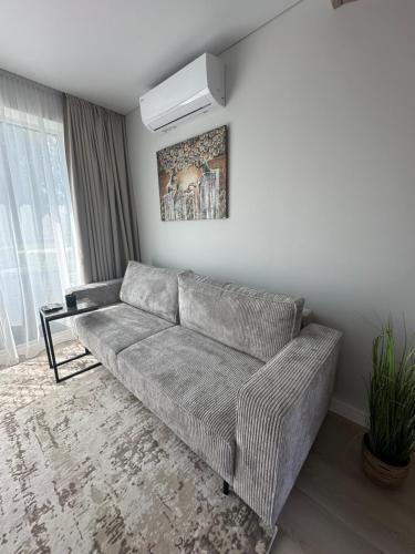 een woonkamer met een bank in een kamer bij Monci Resort in Palanga