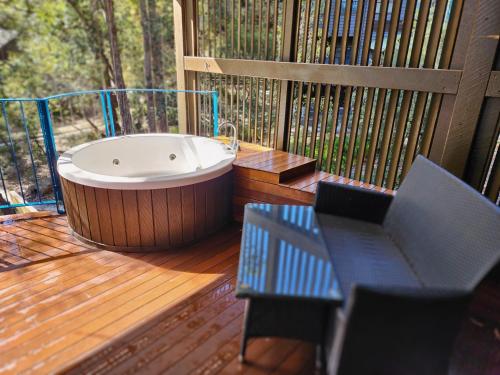 a hot tub on a deck with a table and chairs at Villa 521 Kingfisher Bay Fraser Island in Kingfisher Bay