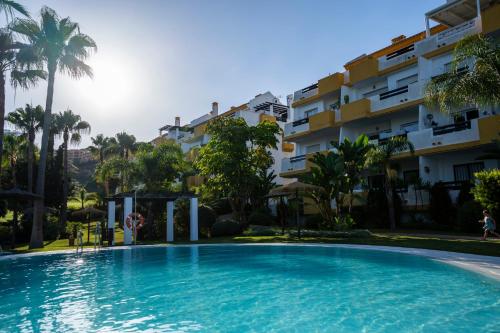 ein Schwimmbad vor einem Gebäude in der Unterkunft Vista Calanova Golf Club Apartment, 2BD Seaviews in La Cala de Mijas