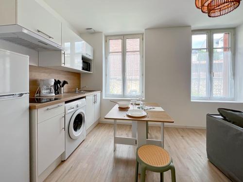 - une cuisine avec une table et un lave-linge/sèche-linge dans l'établissement Élégance en Centre-Ville - 336, à Rouen