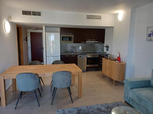 una cucina e un soggiorno con tavolo e sedie in legno di NIDO 210 Garbí a Roses