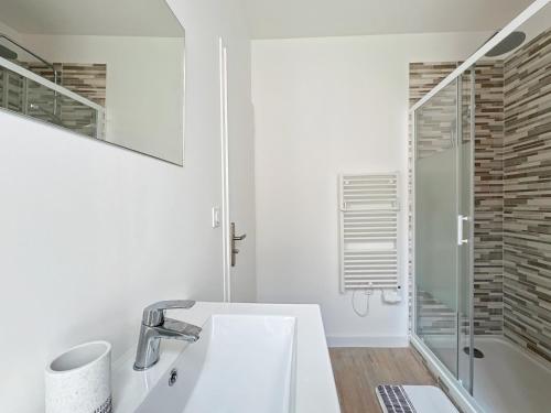 une salle de bain blanche avec un lavabo et une douche dans l'établissement Élégance en Centre-Ville - 336, à Rouen