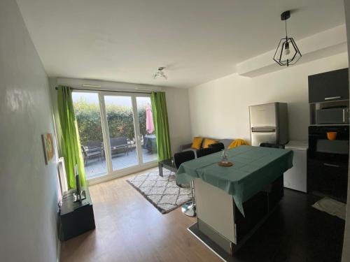 - un salon avec une table verte dans l'établissement Le Romainvillois-Terrasse aux portes de Paris, à Romainville