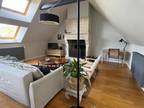 ein Wohnzimmer mit einer weißen Couch und einem Kamin in der Unterkunft Maison proche mer in Agon Coutainville