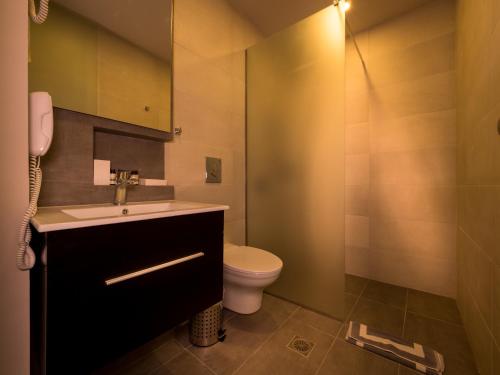 a bathroom with a sink and a toilet at Paradise Resort in Finikounta