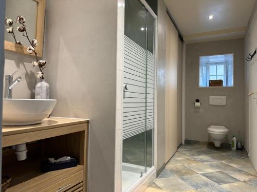 ein Badezimmer mit Glasdusche und Waschbecken in der Unterkunft Maison proche mer in Agon Coutainville