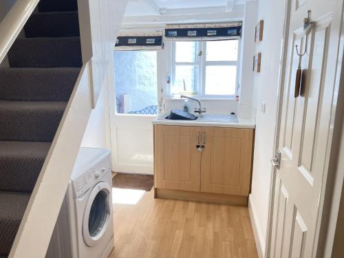 a small kitchen with a sink and a washing machine at Mermaids Rest in St Ives