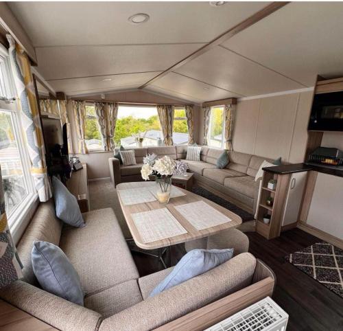 a living room with a couch and a table at Rockley Park Poole caravan-3Bed-On site Activities in Poole
