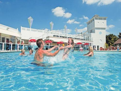 a man and woman playing in the water at a swimming pool at Rockley Park Poole caravan-3Bed-On site Activities in Poole