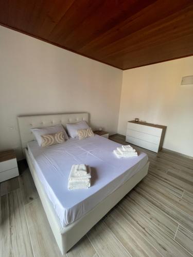 a white bed with two towels on it in a room at Appartamento sul Lago - MEINA in Meina