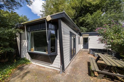 a tiny house with a window and a bench at Rustig gelegen Vakantiehuisje in het bos - Putten in Putten