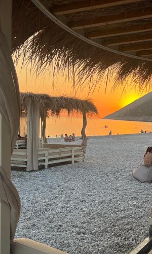 a group of people sitting on the beach at sunset at 3M Villa, Green Coast Resort, Optional-Personal Buggy available in Palasë