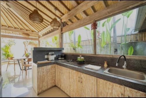 MungguにあるVilla Ramaraのシンクと大きな窓のあるキッチン