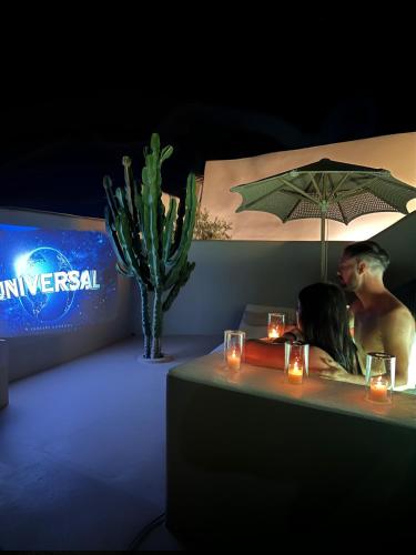a man and a woman sitting at a table under an umbrella at Luna Santorini Suites in Pirgos
